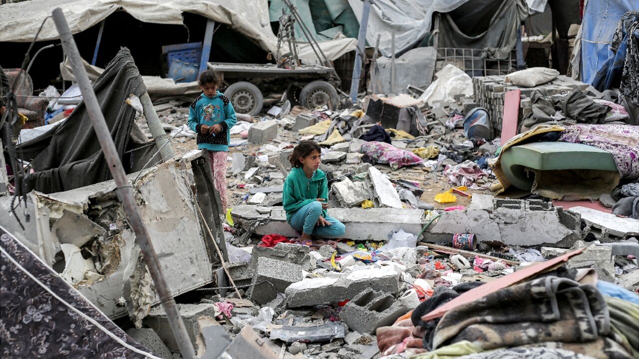 A young girl sat in the midst of a sea of rubble and metal rods after an Israeli strike in Deir el-Balah