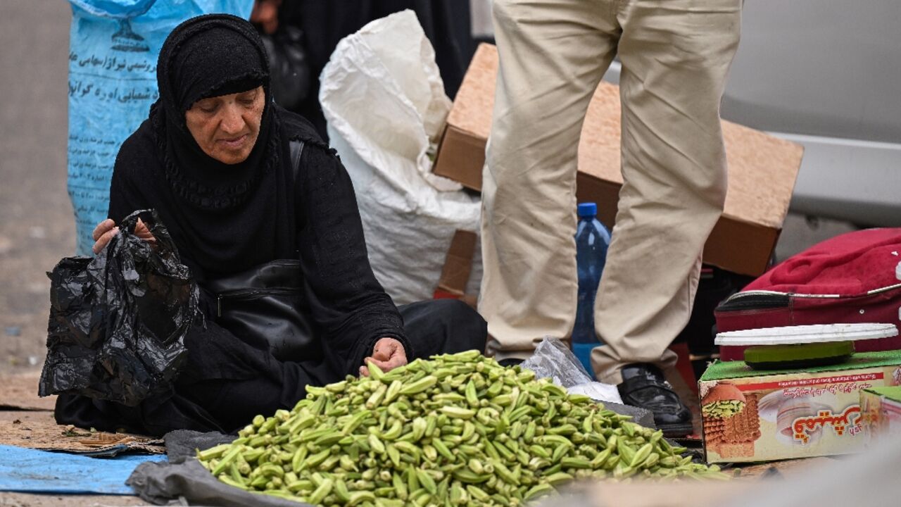 An Iranian woman sells okra at the old market in Iraq's southern city of Basra