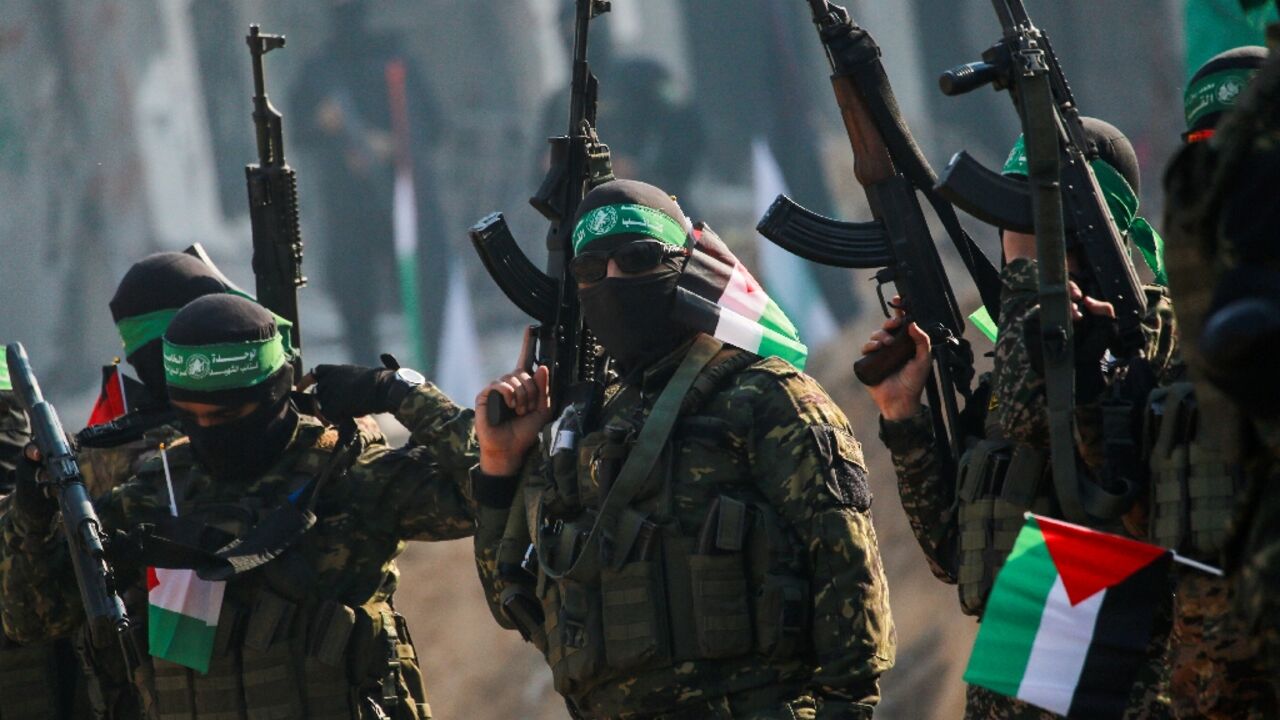Hamas militants stand guard near a stage before releasing an Israeli hostage