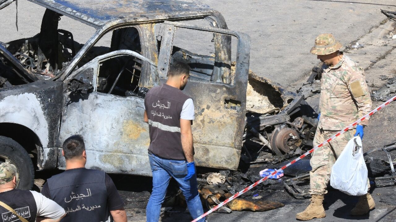 A Lebanese army soldier and forensics experts inspect a burnt-out vehicle in Braiqaa,  in south Lebanon's Nabatiyeh district, after what the military called a munitions blast