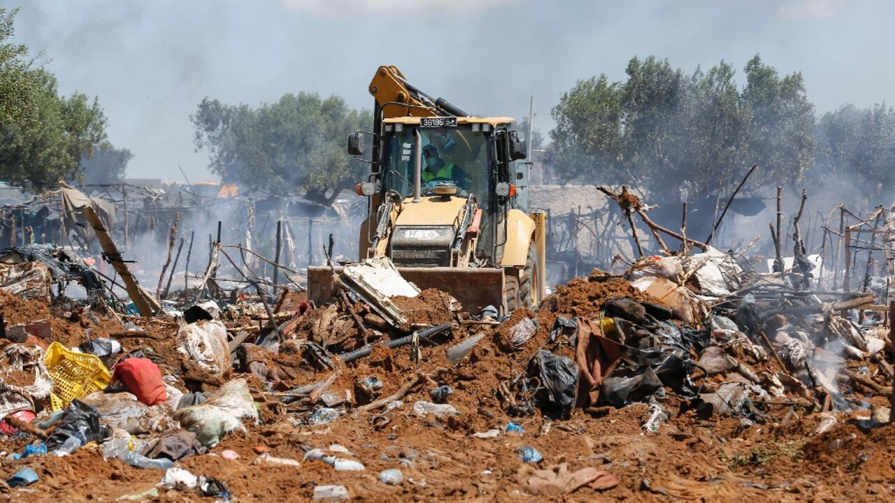 Tunisian security forces dismantle a makeshift camp for migrants from sub-Saharan Africa at El Amra on the outskirts of Sfax city