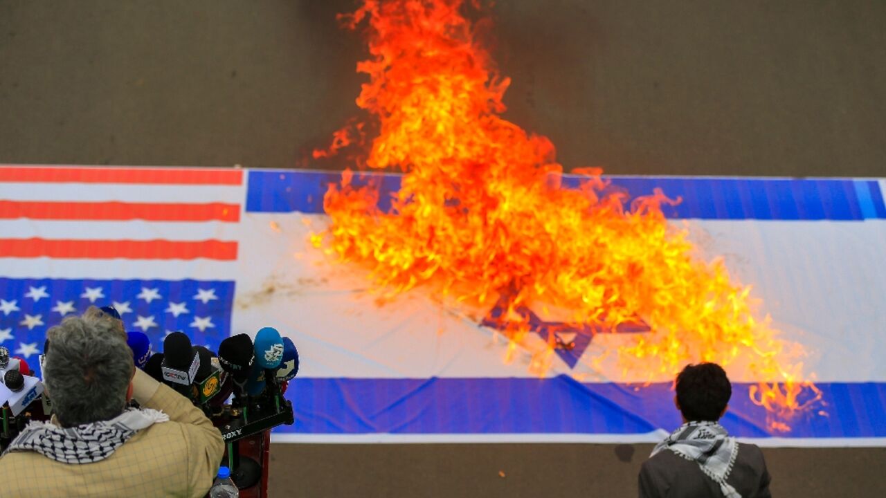 Demonstrators burn US and Israeli flags during a Sanaa rally in solidarity with Palestinians in the Gaza Strip