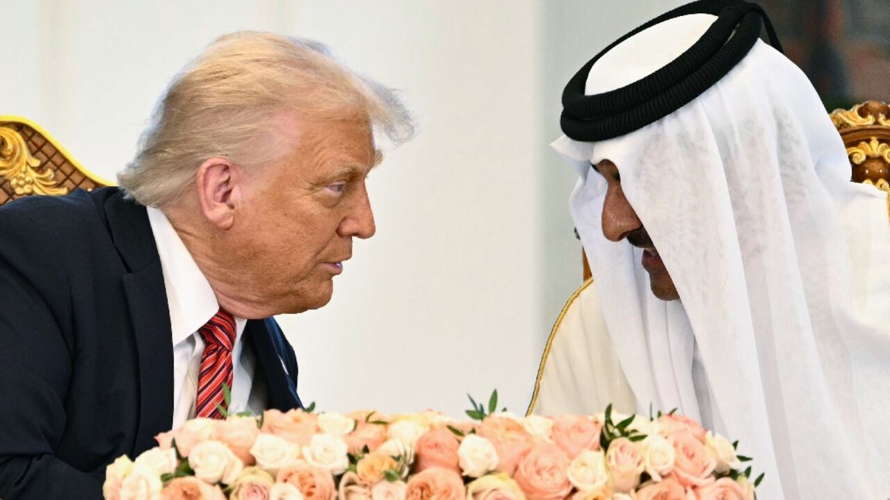 Qatar's Emir Sheikh Tamim bin Hamad al-Thani (R) and US President Donald Trump speak to each other at the Royal Palace in Doha on May 14, 2025