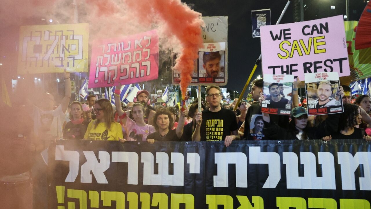 Israelis carry posters of hostages during an anti-government protest calling for an end to the war in Gaza