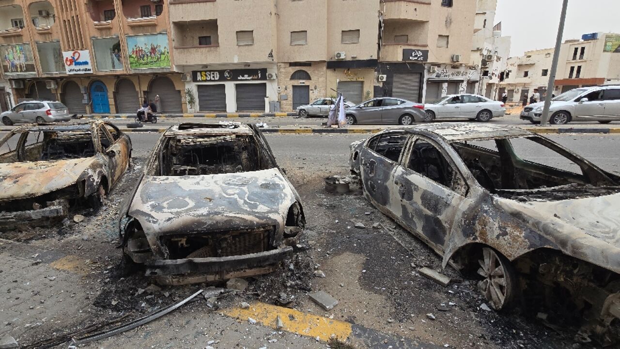 Burnt cars line a street in Tripoli following renewed clashes in Libya's capital