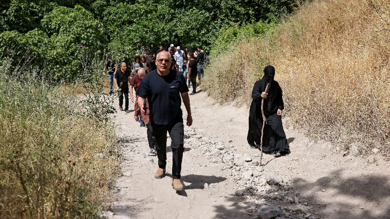 Arab Israelis walk through the overgrown ruins of the Palestinian village of Al-Lajjun, deserted since 1948, to commemorate the "catastrophe" of Israel's creation.