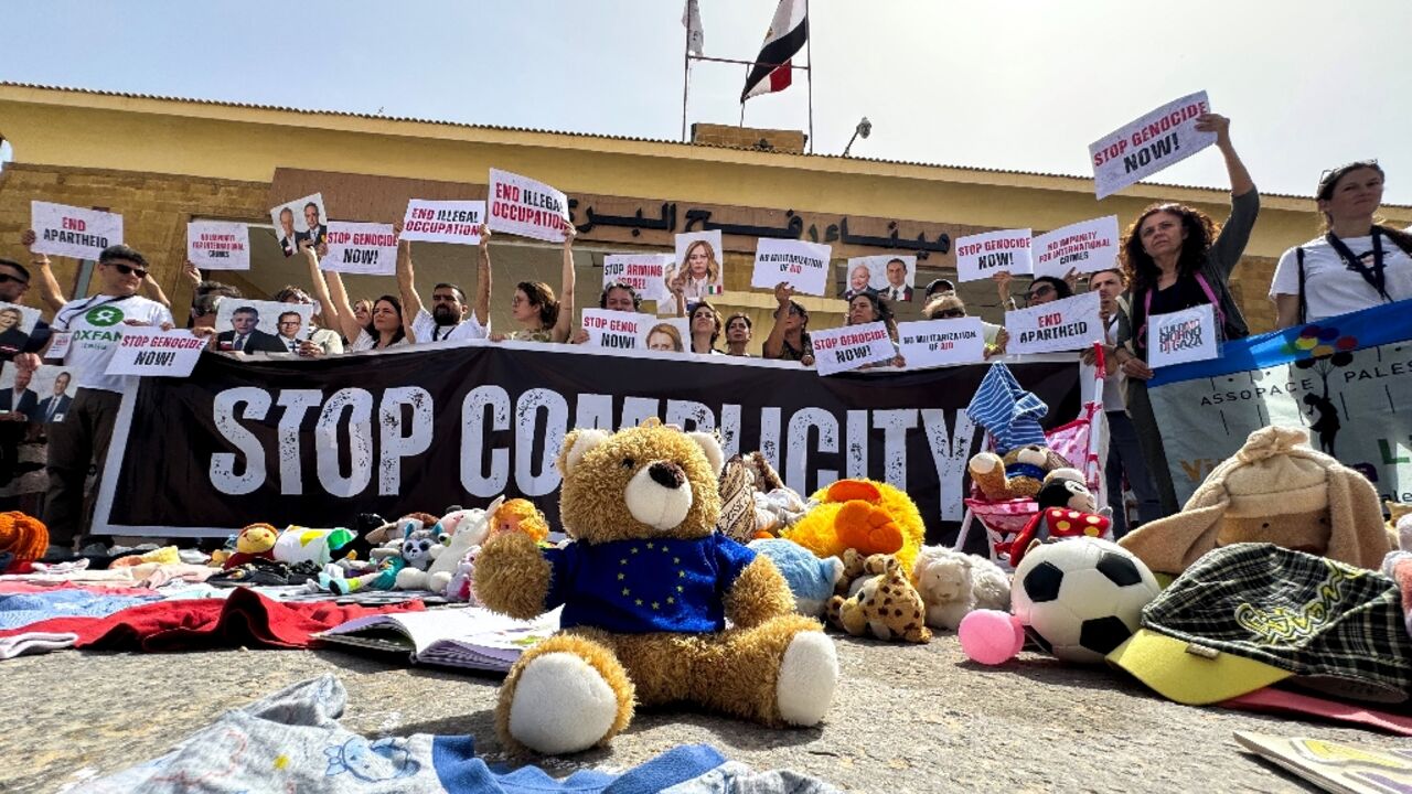 Italian parliamentarians hold placards during their protest at Egypt's side of the Rafah border crossing into Gaza