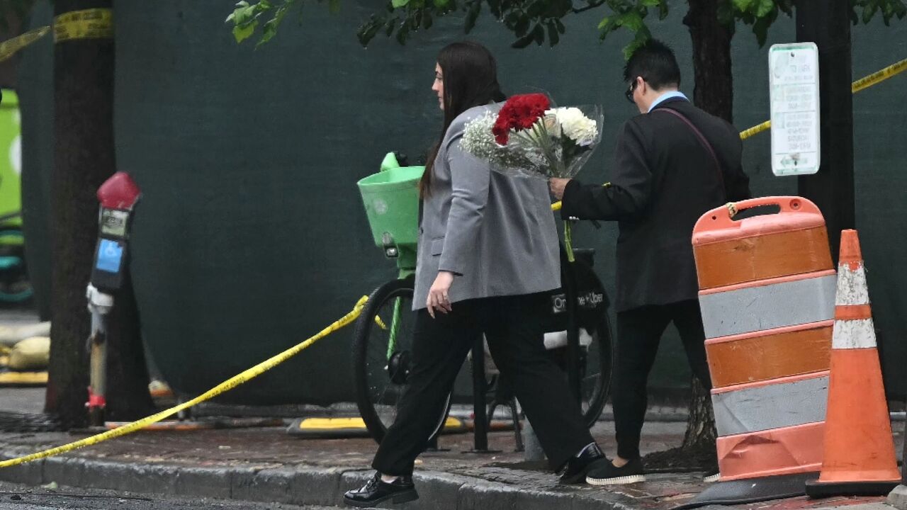 People deliver flowers to the crime site outside the Capital Jewish Museum