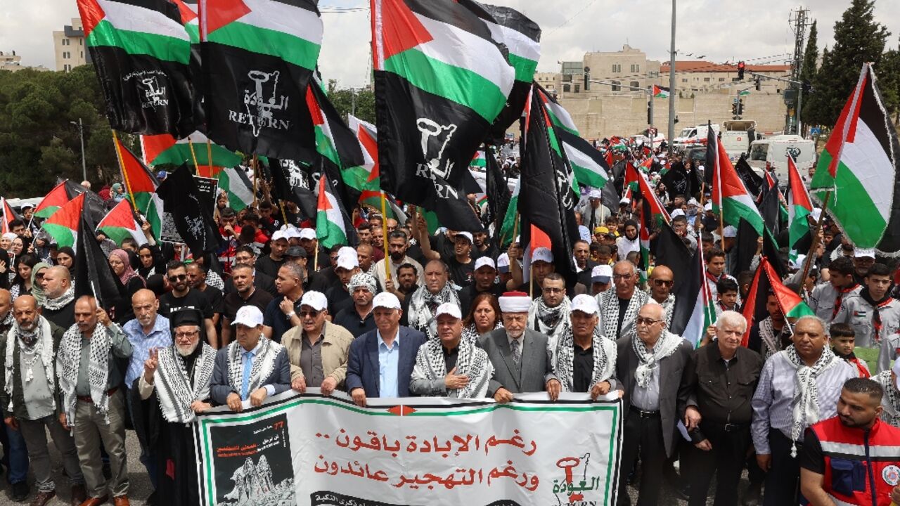 Palestinians wave national flags as they commemorate the 77th anniversary of the "Nakba" in the city of Ramallah