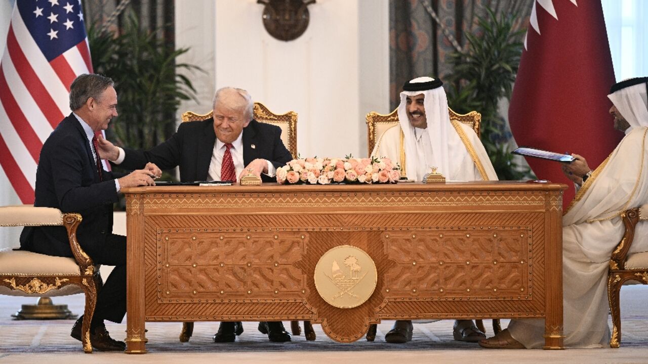 Boeing CEO Kelly Ortberg sits to the left of US President Donald Trump and Qatar's Emir Sheikh Tamim bin Hamad al-Thani (R) during a business deal signing ceremony at the Royal Palace in Doha, on May 14, 2025