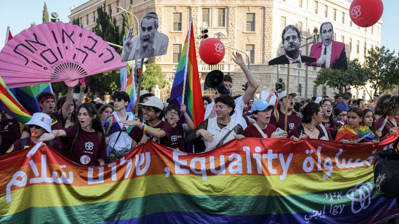 Participants march with a giant pride flag during the annual Jerusalem Pride Parade in the city centre