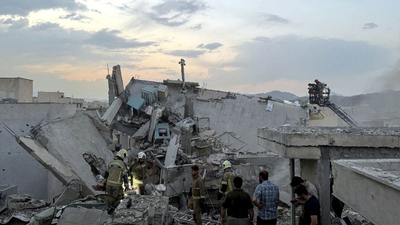 First responders clamber over the rubble of a Tehran building hit by an Israeli strike.