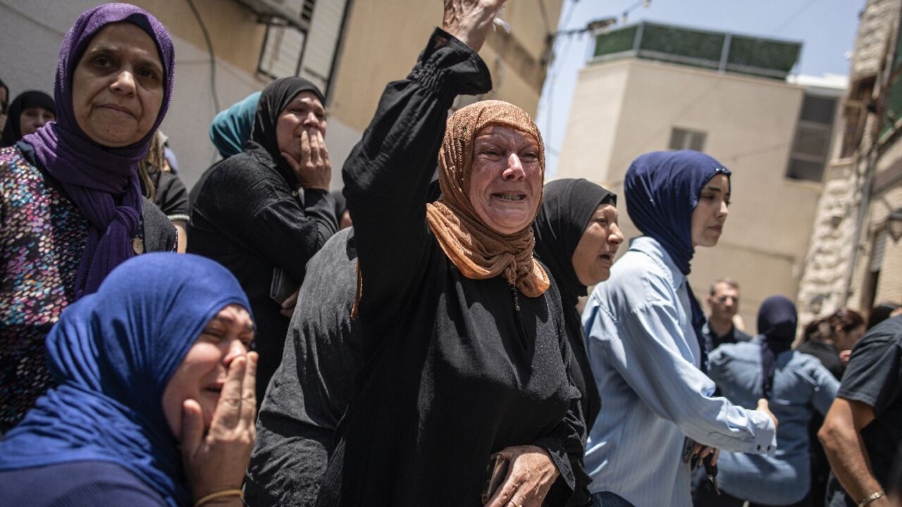 Mourners at a funeral for victims of an Iranian missile attack which destroyed a three-storey building in the northern city of Tamra 