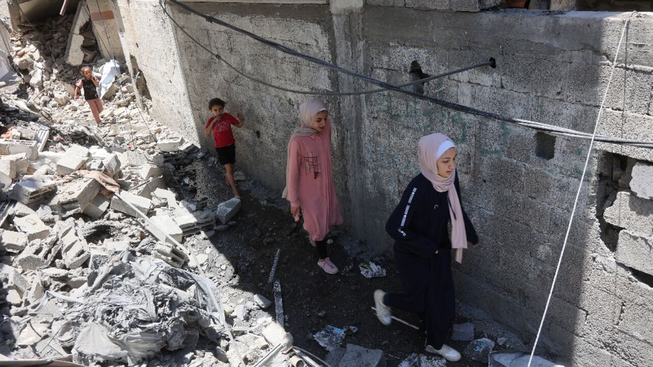Palestinians children walk amid the rubble of a home that was targeted in an Israeli strike in Jabalia on Monday