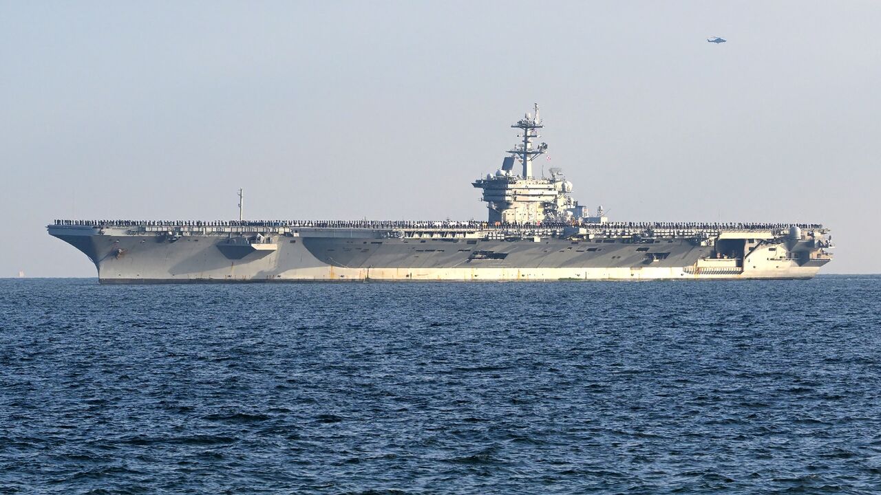 Members of the crew line the deck of the USS George Washington as the nuclear-powered aircraft carrier moves into Tokyo Bay to the US naval base at Yokosuka, Kanagawa prefecture, south of Tokyo, Nov. 22, 2024.