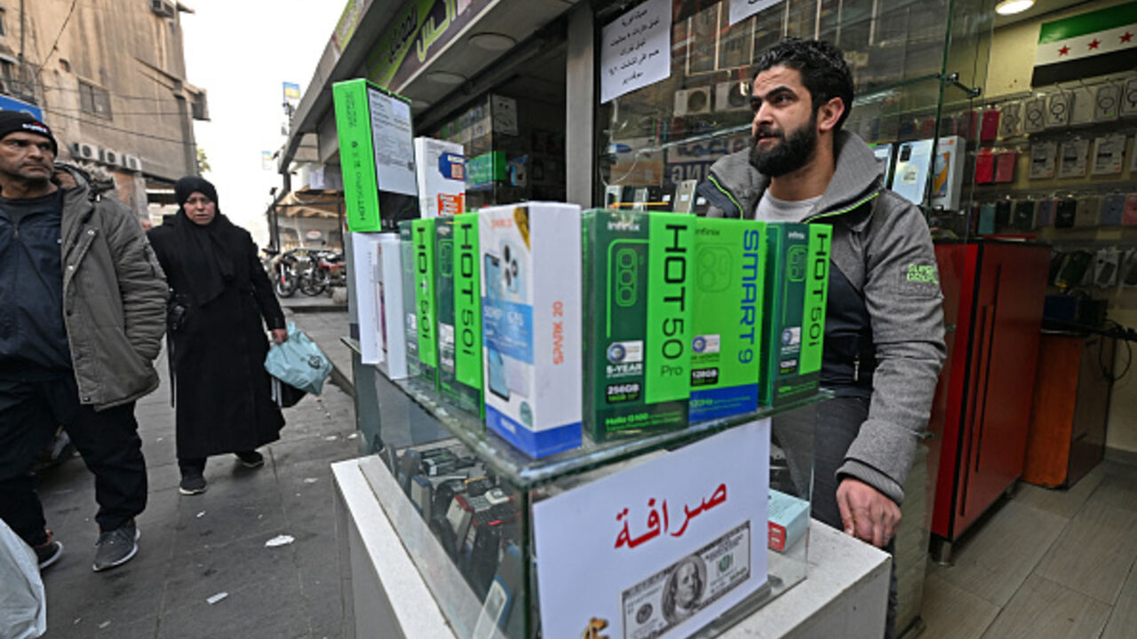 A vendor waits for customers at his mobile shop in the Damascus Tower market, which specializes in the smart phone business, in the Syrian capital on January 12, 2025. Before President Bashar al-Assad was ousted in December 2024, security forces would raid the central Damascus district that is home to dozens of mobile stores in search of phones without the logo of an Assad-linked company which enjoyed a monopoly in the business. (Photo by Louai BESHARA / AFP) / To go with 'Syria-War-Telecom-Sanction', REPOR