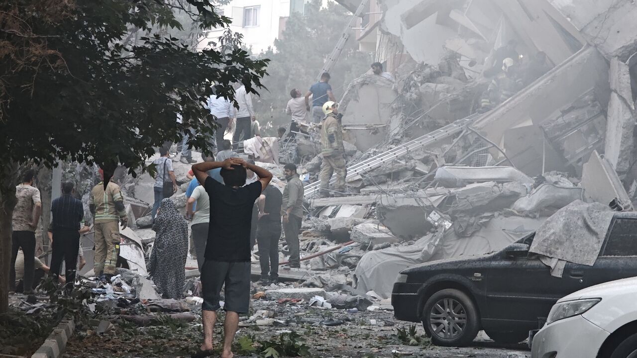 People look over damage to buildings in Nobonyad Square following Israeli airstrikes on Tehran, June 13, 2025.