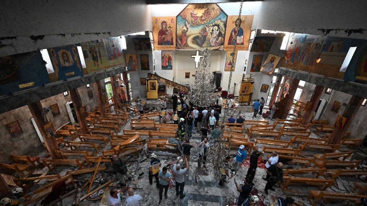 People inspect the damage at the site of a suspected suicide attack at the Saint Elias church in Damascus