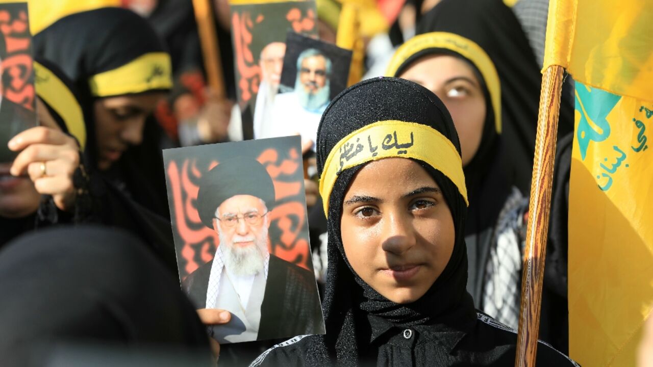 Supporters of Lebanese militant group Hezbollah hold pictures of Iran's supreme leader Ayatollah Ali Khamenei as they celebrate Iran's "victory" over Israel outside the Iranian embassy in Beirut.