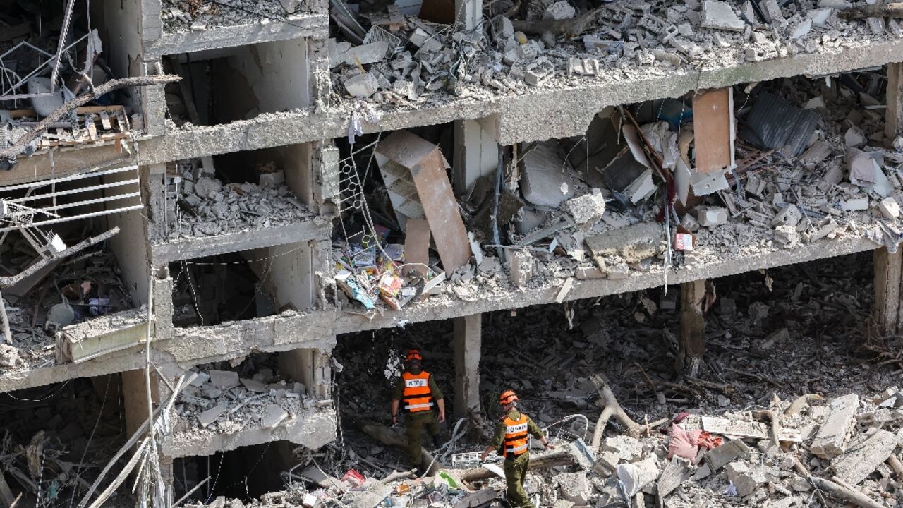 Israeli security forces and first responders gather at the site of an Iranian strike that hit a residential neighbourhood in the Ramat Aviv area in Tel Aviv