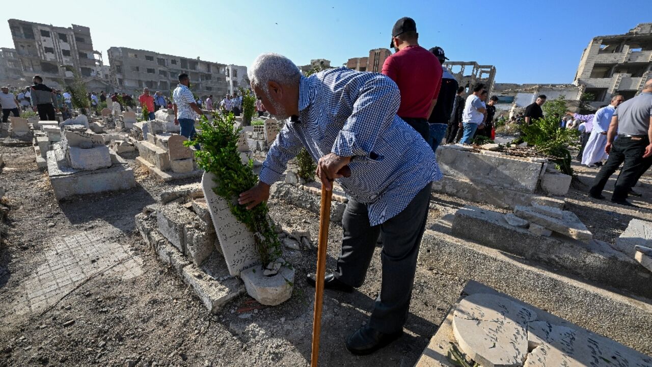 Syrians visit the graves of their loved ones in the Jobar suburb of Damascus on the first day of Eid al-Adha