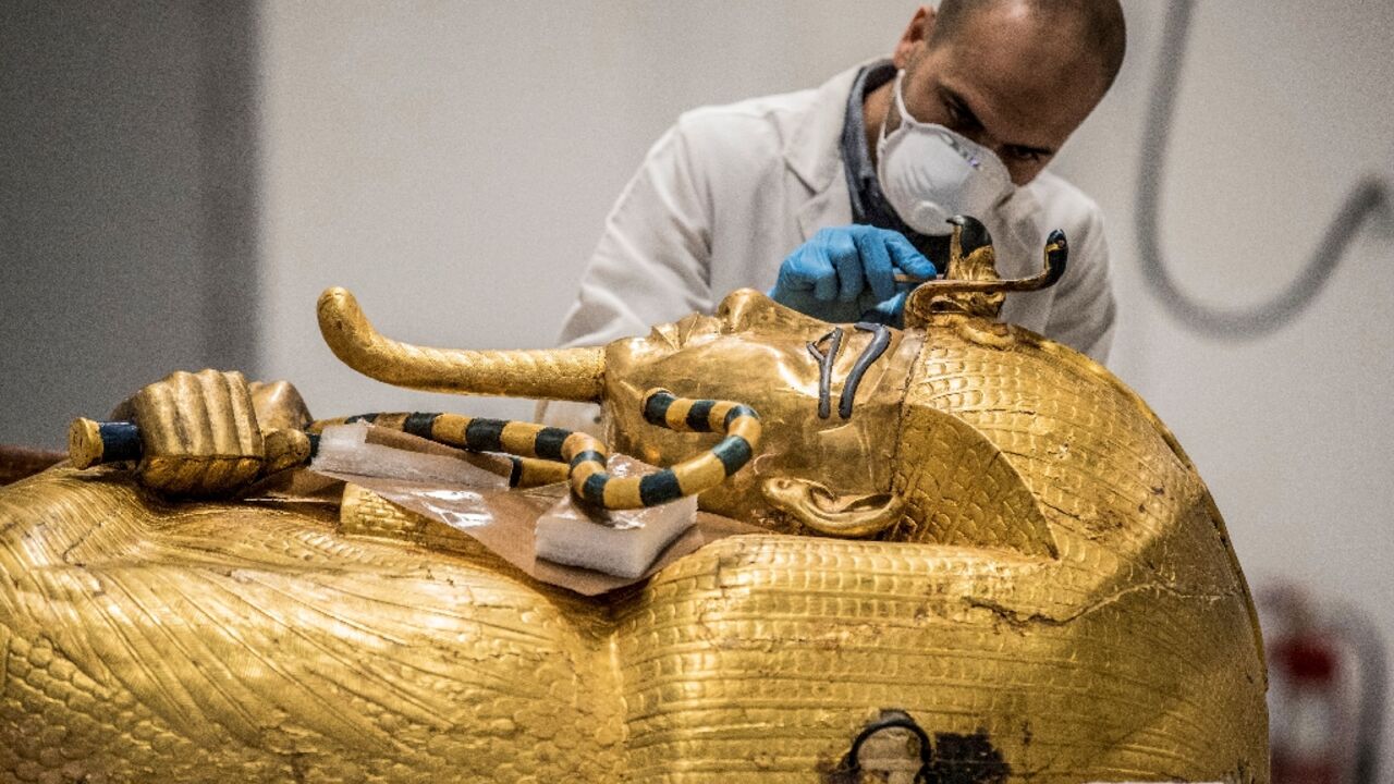 An archaeologist performs restorations on the sarcophagus of Pharaoh Tutankhamun in the restoration lab of the Grand Egyptian Museum in 2020