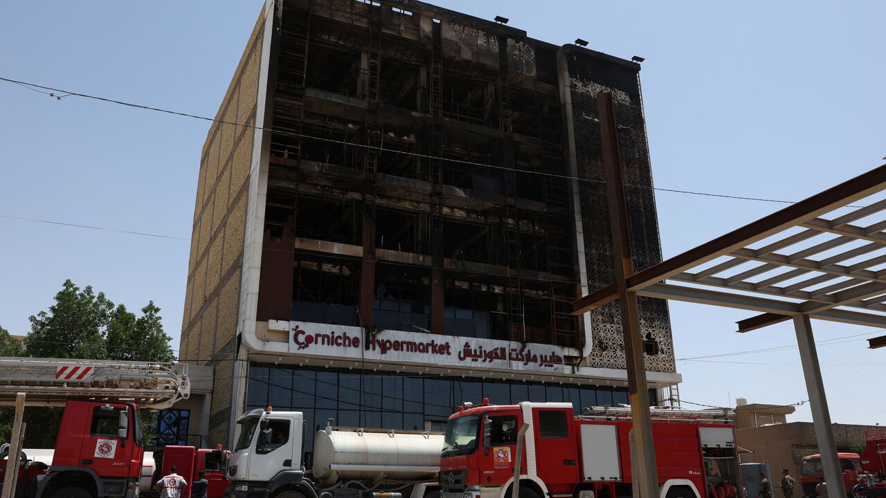 Fire trucks stand next to the wreckage of a shopping center, after a massive overnight fire killed dozens of people, in al-Kut, Wasit province, Iraq, July 17, 2025. REUTERS/Ahmed Saad