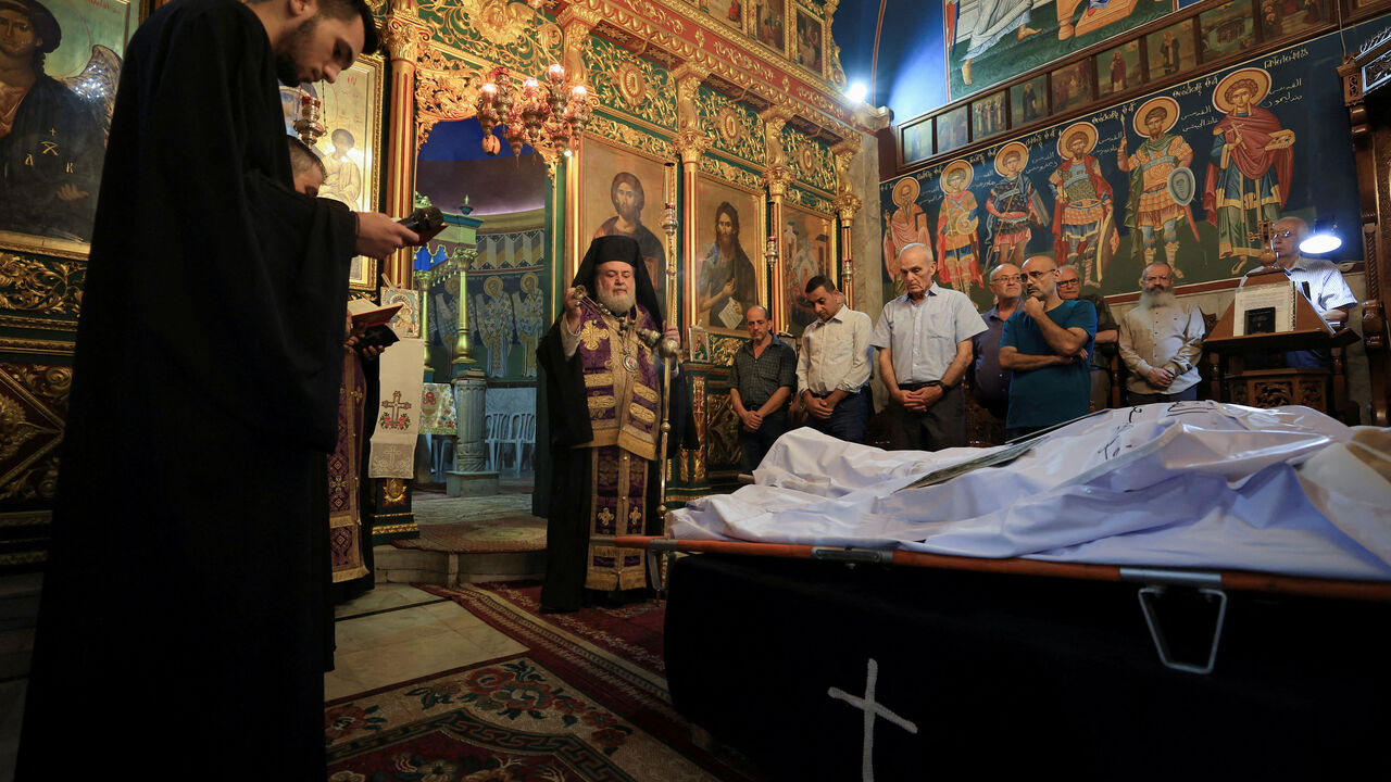 Archbishop Alexios stands in front of the bodies of Palestinian Christians Saad Salama and Foumia Ayyad, who were killed in an Israeli strike on the Holy Family Church, according to medics, as mourners attend their funeral at the Greek Orthodox Saint Porphyrius Church, in Gaza City, July 17, 2025. REUTERS/Dawoud Abu Alkas