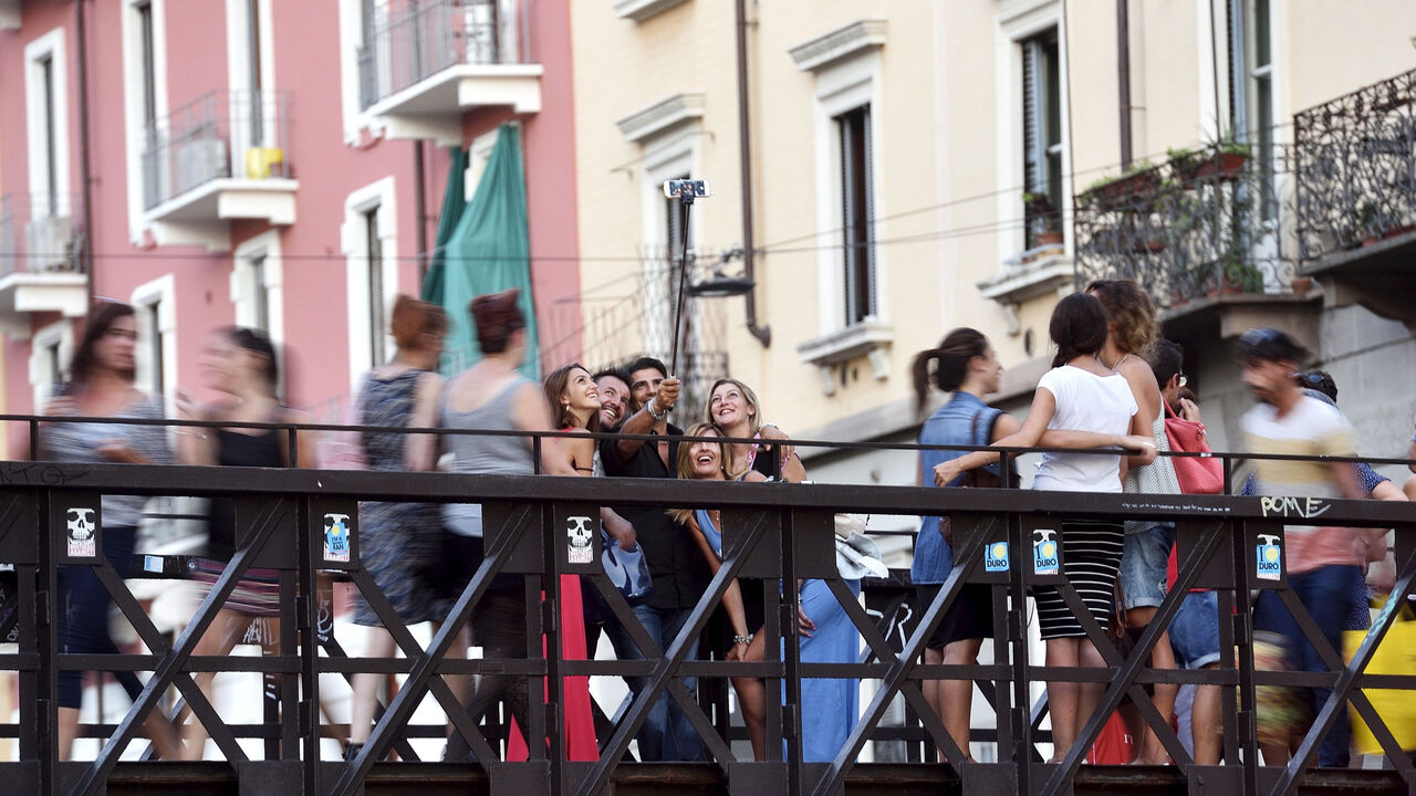FILE PHOTO: People take a selfie at Naviglio Gran Canal in Milan, August 29, 2015. REUTERS/Flavio Lo Scalzo/File Photo