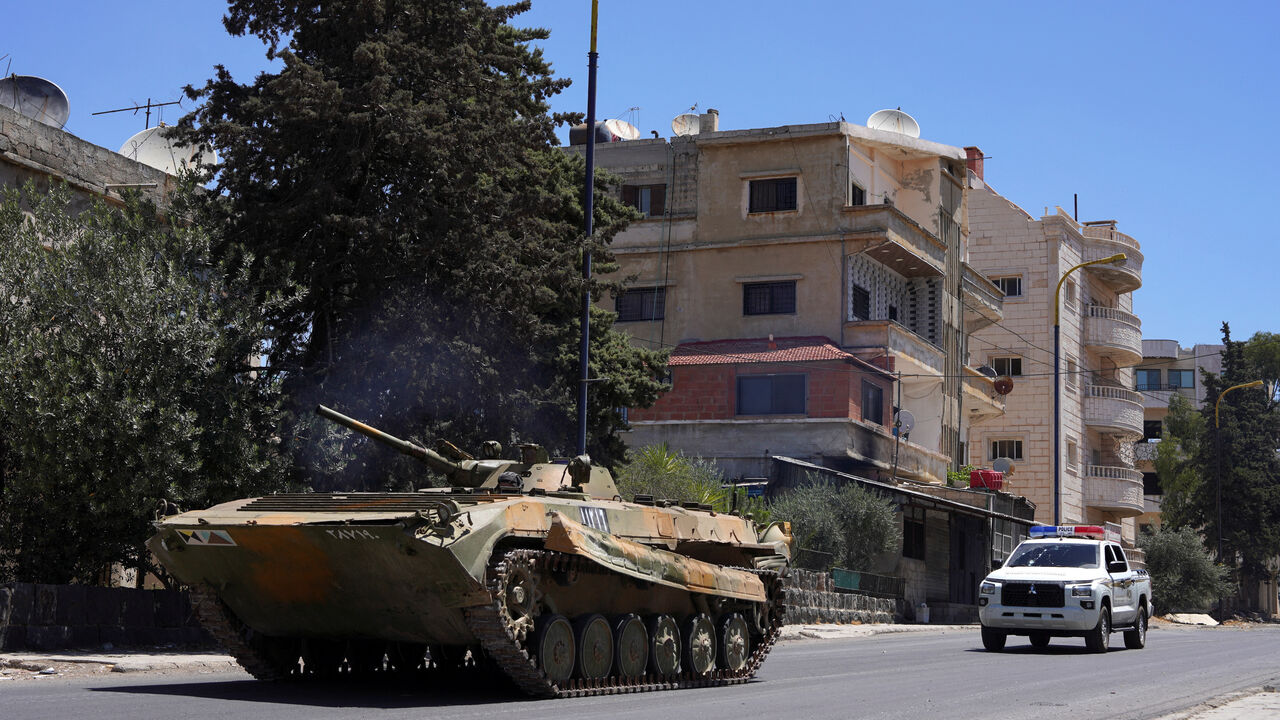 FILE PHOTO: A military vehicle drives along a street, after clashes between Syrian government troops and local Druze fighters resumed in the southern Druze city of Sweida early on Wednesday, collapsing a ceasefire announced just hours earlier that aimed to put an end to days of deadly sectarian bloodshed, in Sweida, Syria July 16, 2025. REUTERS/Karam al-Masri/File Photo