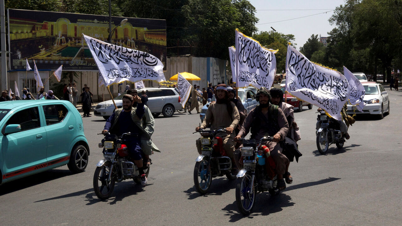 FILE PHOTO: Members of the Taliban carrying flags ride motorbikes as they participate in a rally to mark the third anniversary of the fall of Kabul, in Kabul, Afghanistan, August 14, 2024. REUTERS/Sayed Hassib/File Photo