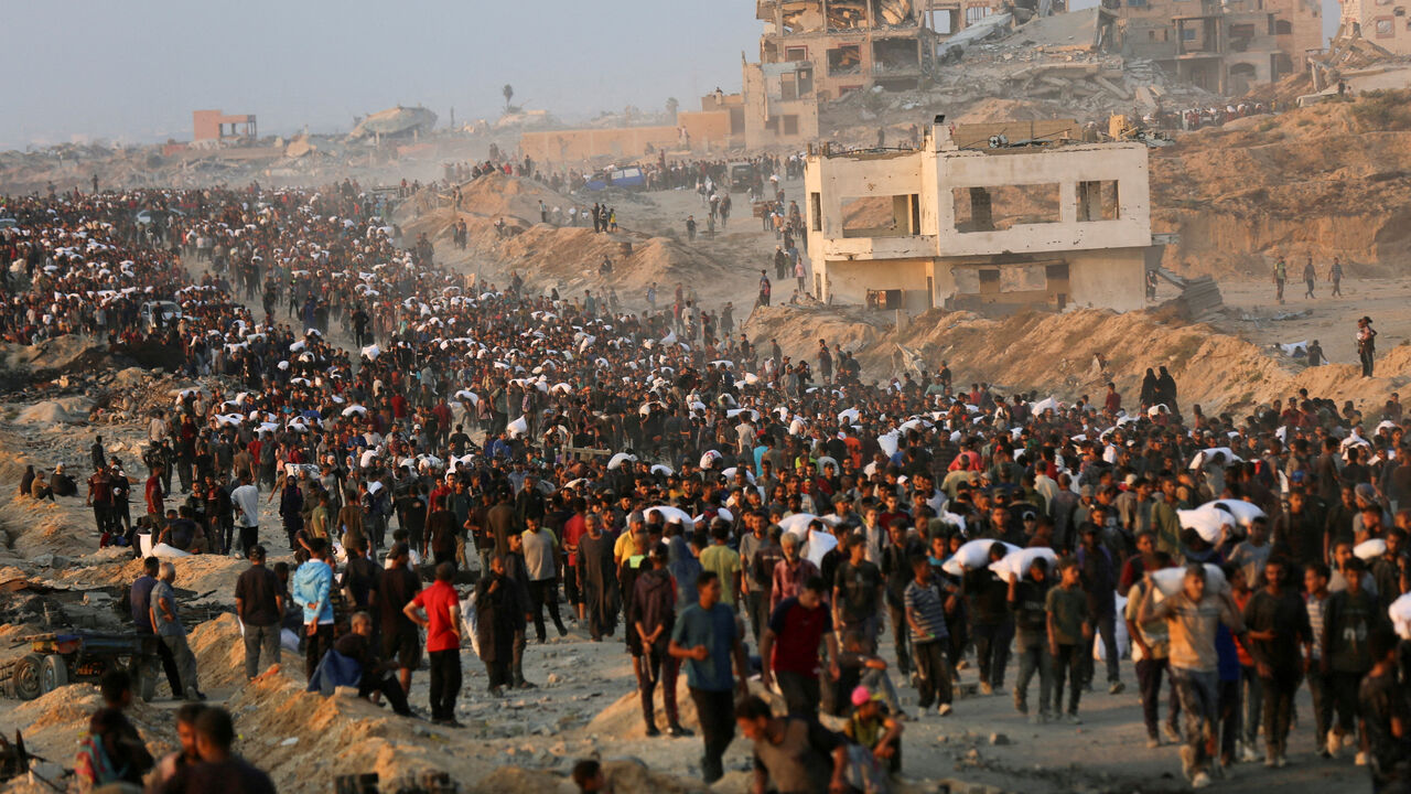 FILE PHOTO: Palestinians gather to receive aid supplies in Beit Lahia, in the northern Gaza Strip, June 17, 2025. REUTERS/Stringer/File Photo