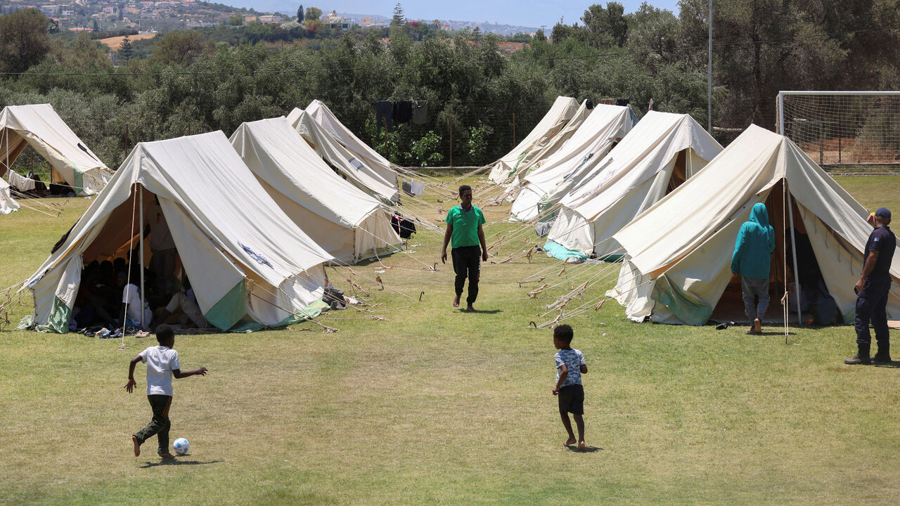 FILE PHOTO: Children play by the tents, as recently arrived migrants shelter at the temporary migrants' camp staged on a soccer pitch in the region of Rethymno in Crete island, Greece, June 24, 2025. REUTERS/Stefanos Rapanis/File Photo