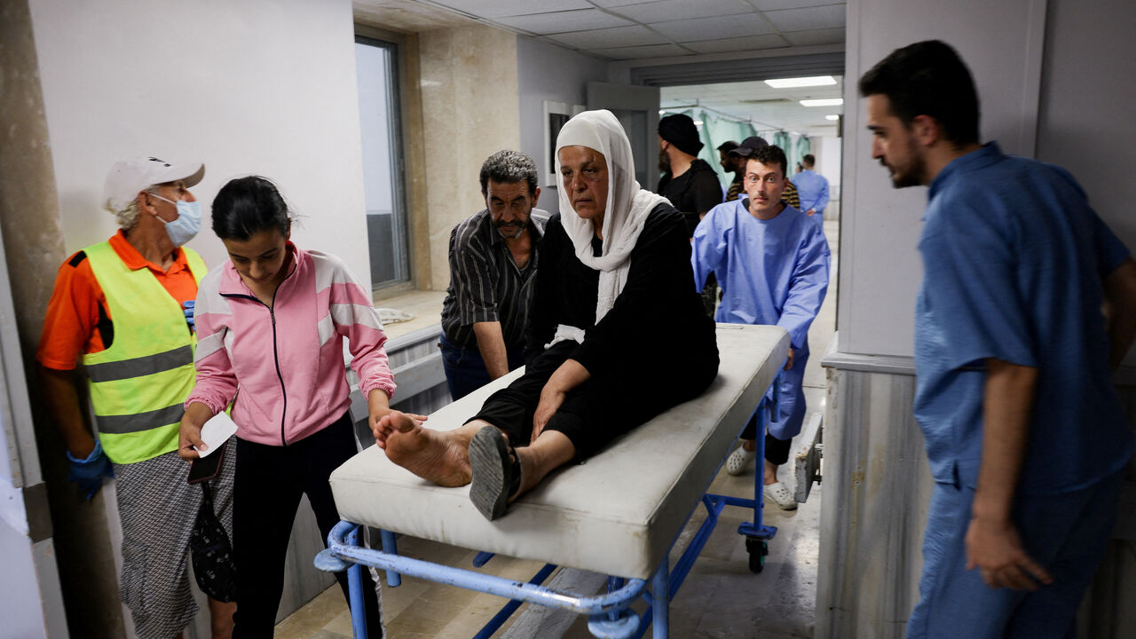 A woman is assisted at a hospital, following deadly clashes between Druze fighters, Sunni Bedouin tribes and government forces, in Syria's predominantly Druze city of Sweida, Syria July 25, 2025. REUTERS/Khalil Ashawi