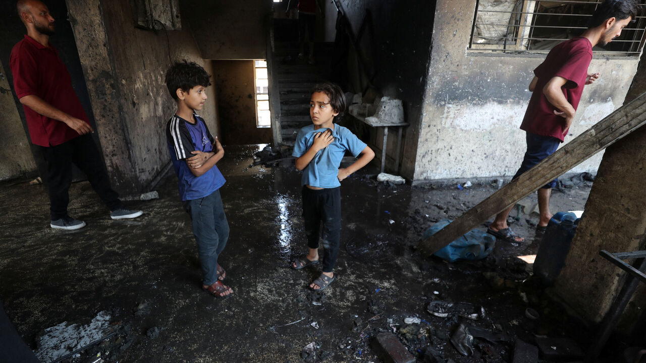 Palestinian children stand at the site of an Israeli strike on a school sheltering displaced people, in Gaza City, July 25, 2025. REUTERS/Mahmoud Issa/File Photo