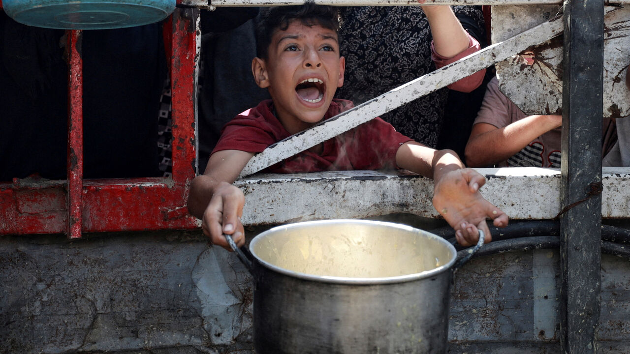 A Palestinian reacts as he waits to receive food from a charity kitchen, amid a hunger crisis, in Gaza City, July 28, 2025. REUTERS/Khamis Al-Rifi