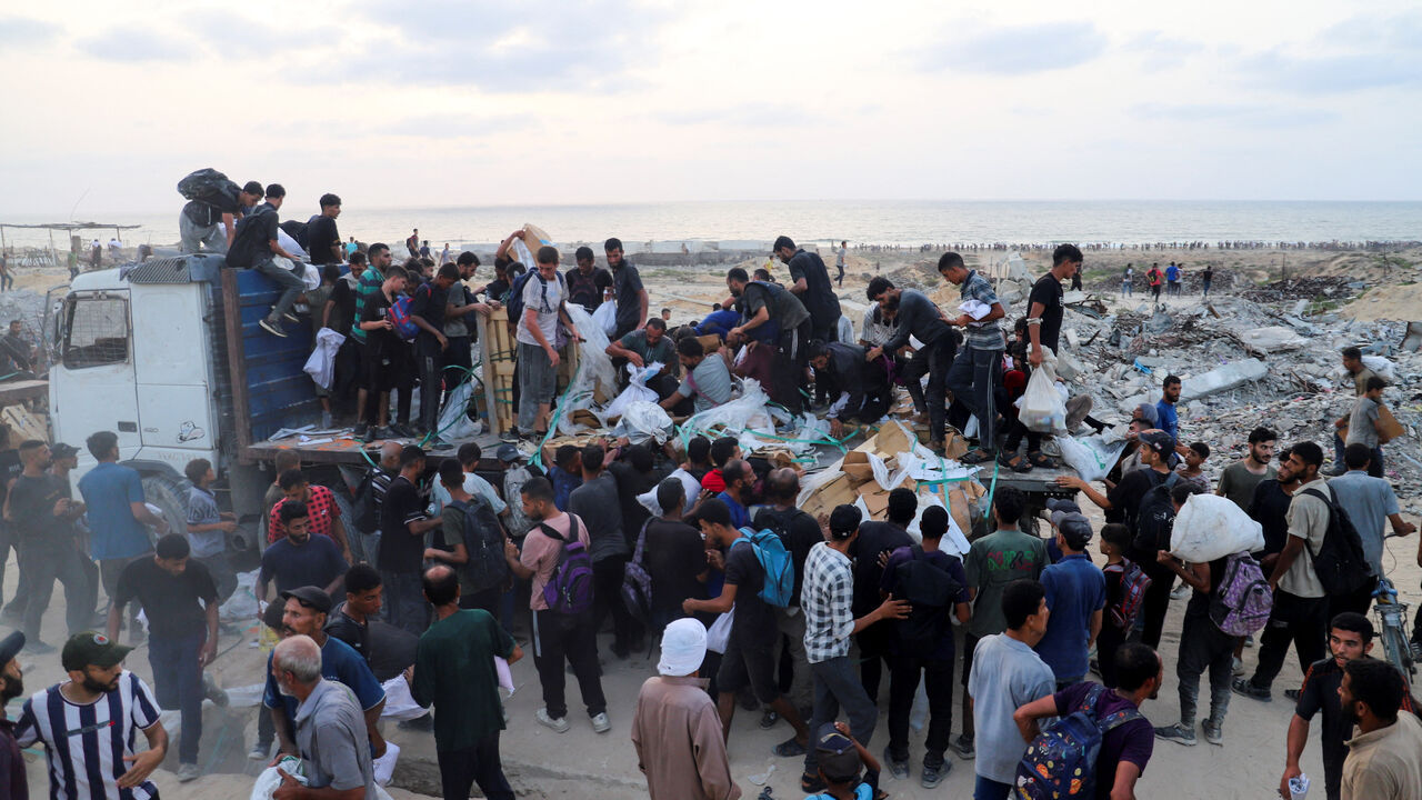 Palestinians gather to receive aid supplies from a truck, which entered Gaza through Israel, in Beit Lahia, in the northern Gaza Strip July 29, 2025. REUTERS/Ebrahim Hajjaj