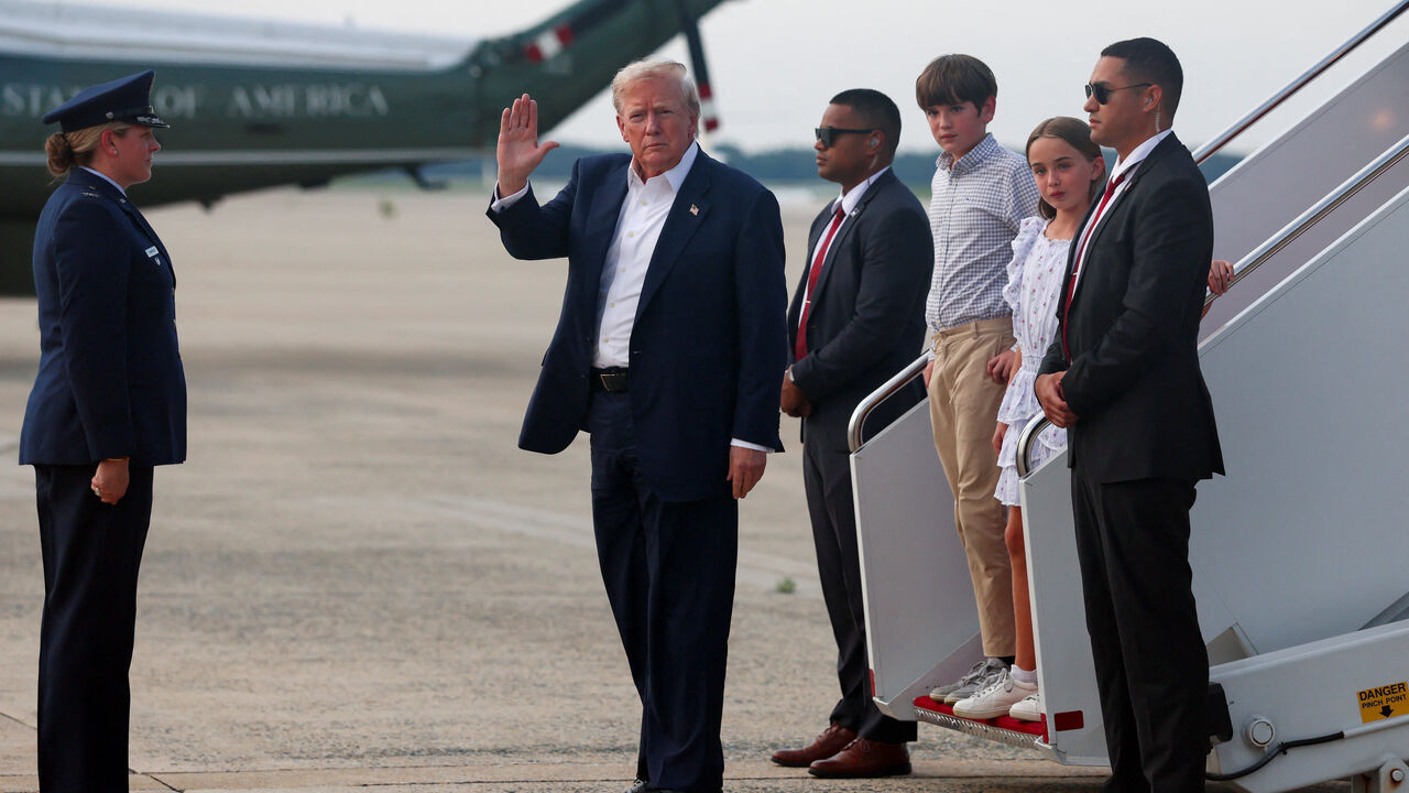 U.S. President Donald Trump, accompanied by his grandchildren Chloe Trump and Spencer Trump, waves as he disembarks from Air Force One as he returns from Scotland, Britain, at Joint Base Andrews, Maryland, U.S., July 29, 2025. REUTERS/Evelyn Hockstein