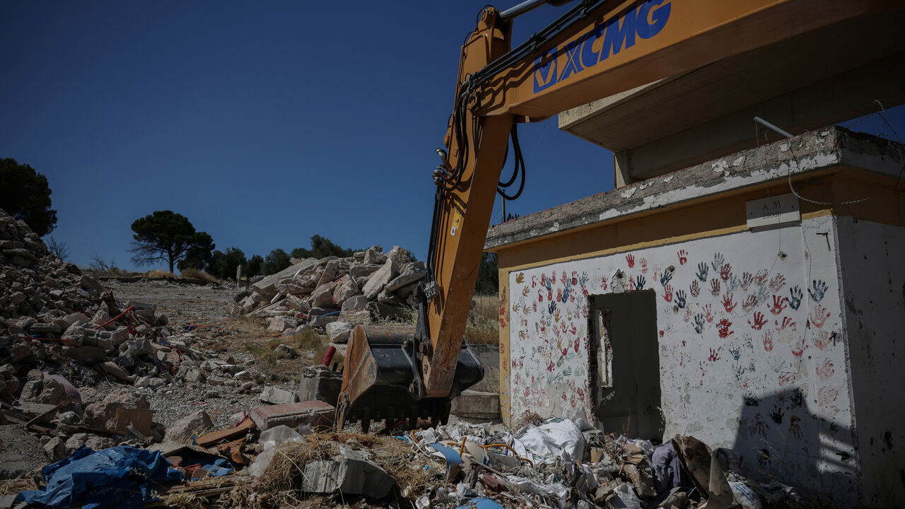 A bulldozer is parked by a partially demolished building at the Moria refugee camp, near the village of Moria, Lesbos island, June 26,2025. REUTERS/Louisa Gouliamaki