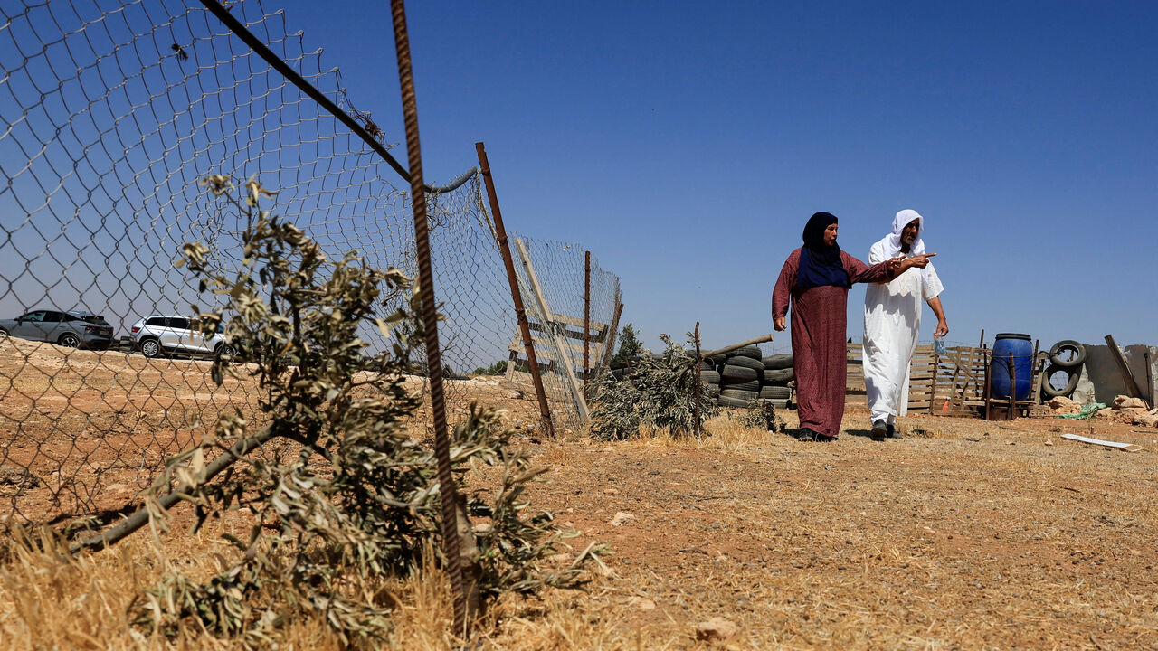 Palestinian Mohammad Moghannam walks home with his wife in Susiya near Hebron, in the Israeli-occupied West Bank July 22, 2025. REUTERS/Mussa Qawasma