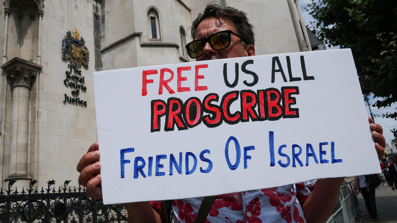 A demonstrator holds a placard, outside London's High Court as judges decide whether the co-founder of Palestine Action can challenge the UK government's ban on the group, in London, Britain, July 30, 2025. REUTERS/Toby Melville