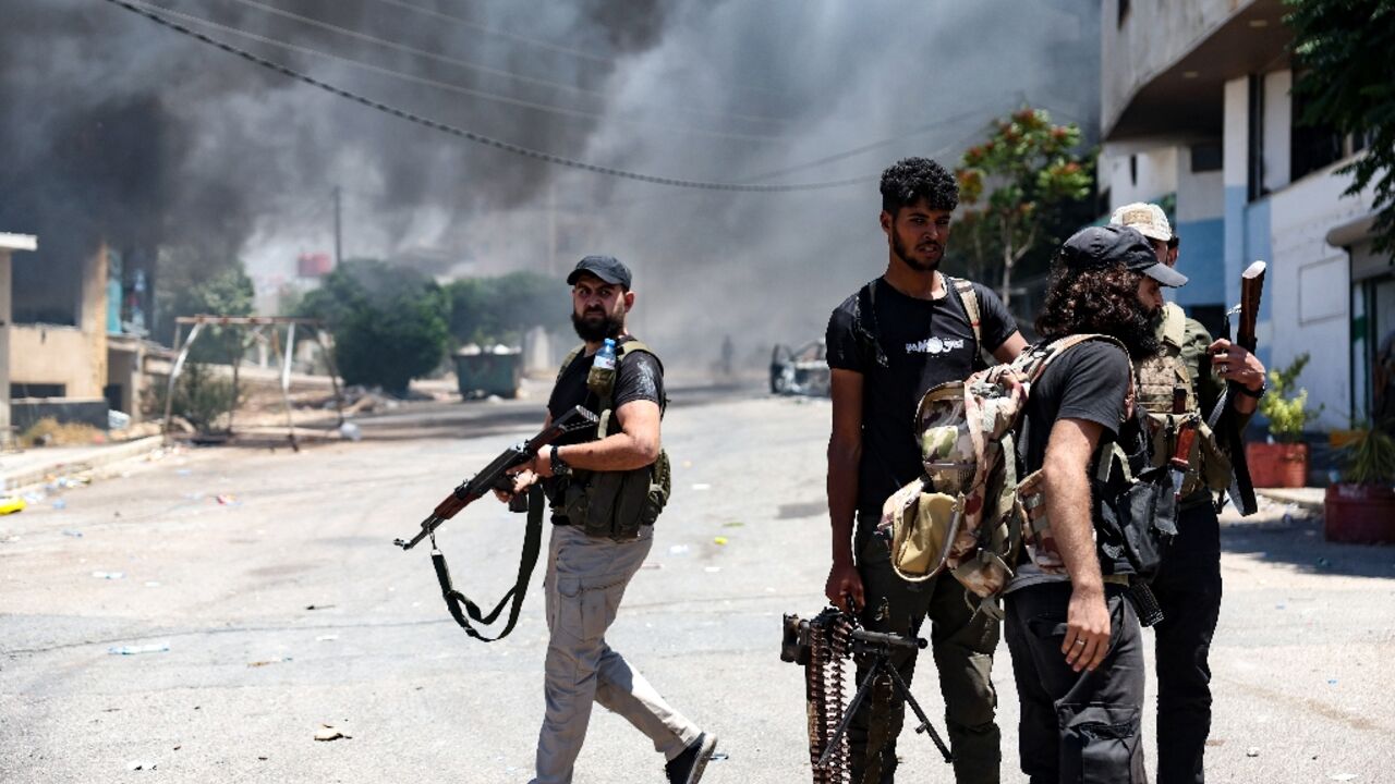 A thick pall of smoke rises over the Syrian city of Sweida as armed Bedouin and their allies battle Druze fighters on the streets despite a ceasefire order from the president's office.