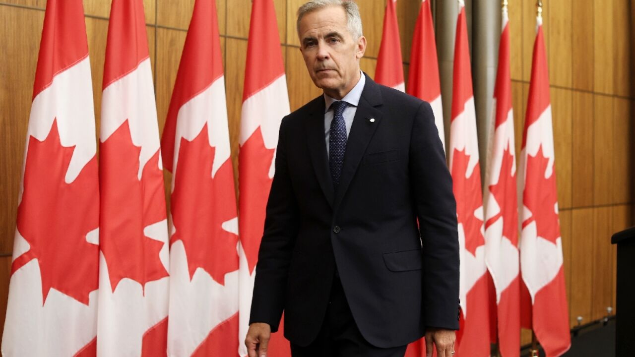Canadian Prime Minister Mark Carney exits a press conference after announcing plans to recognize a Palestinian state