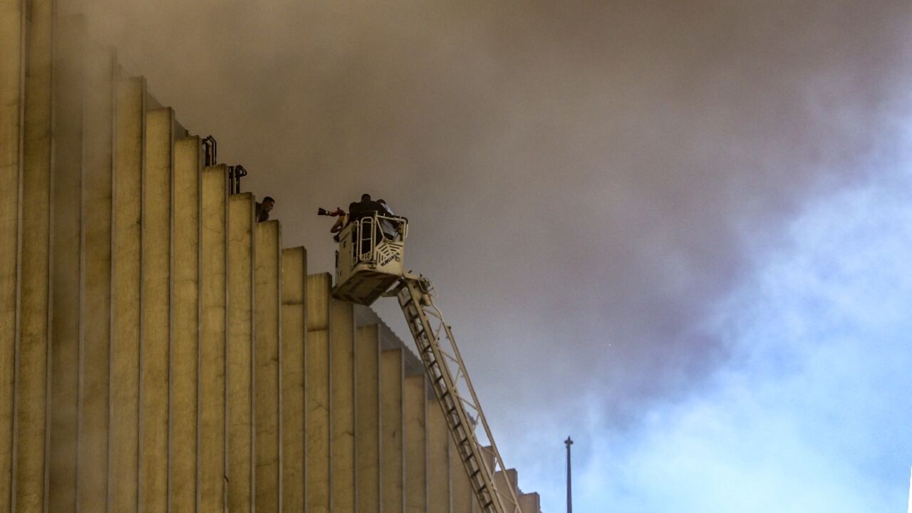 Firefighters douse the flames after a fire broke out in a key telecomms hub in the Egyptian capital