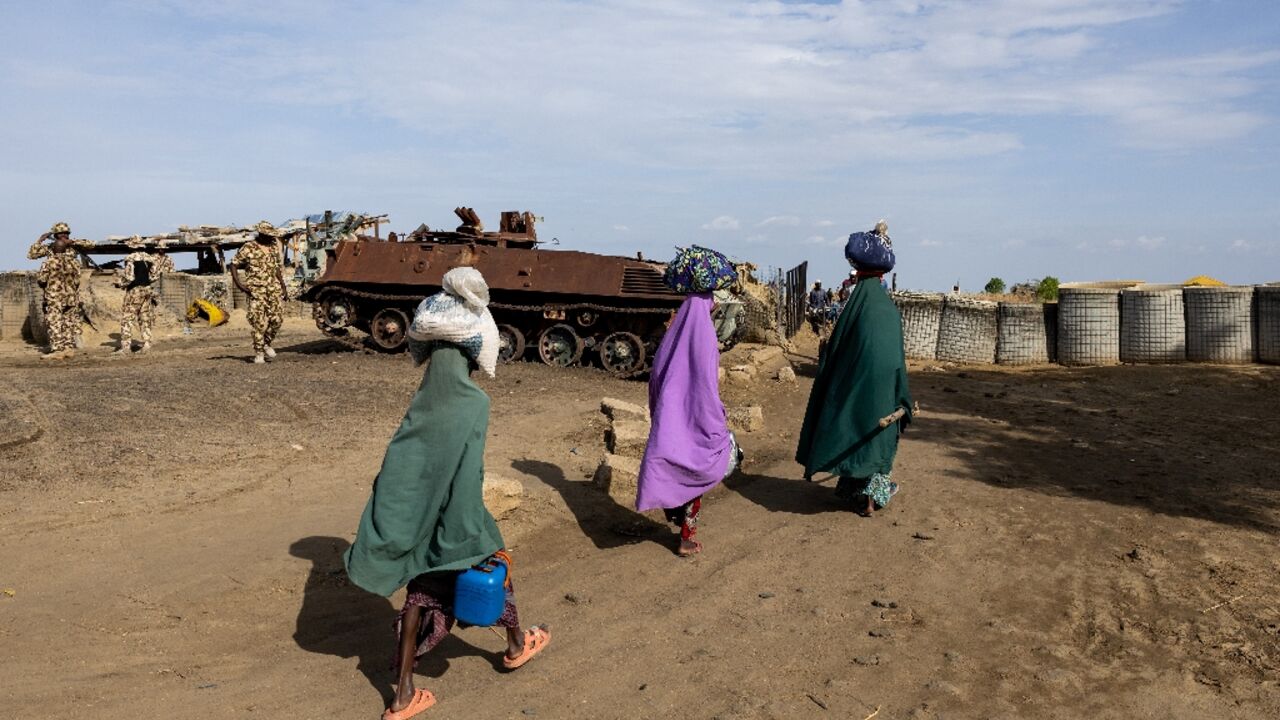 Pedestrians walk past a checkpoint to exit Monguno town Borno state, Nigeria