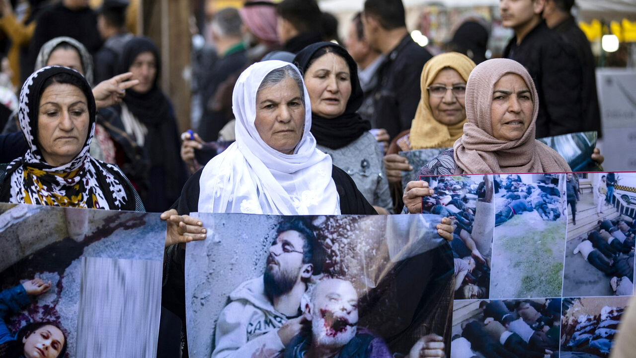 EDITORS NOTE: Graphic content / Women march with pictures of victims of a recent wave of sectarian violence targeting Syria's Alawite minority in the west of the country along the Mediterranean sea coast, during a protest condemning the attacks in Syria's northeastern city of Qamishli on March 11, 2025. (Photo by Delil SOULEIMAN / AFP) (Photo by DELIL SOULEIMAN/AFP via Getty Images)