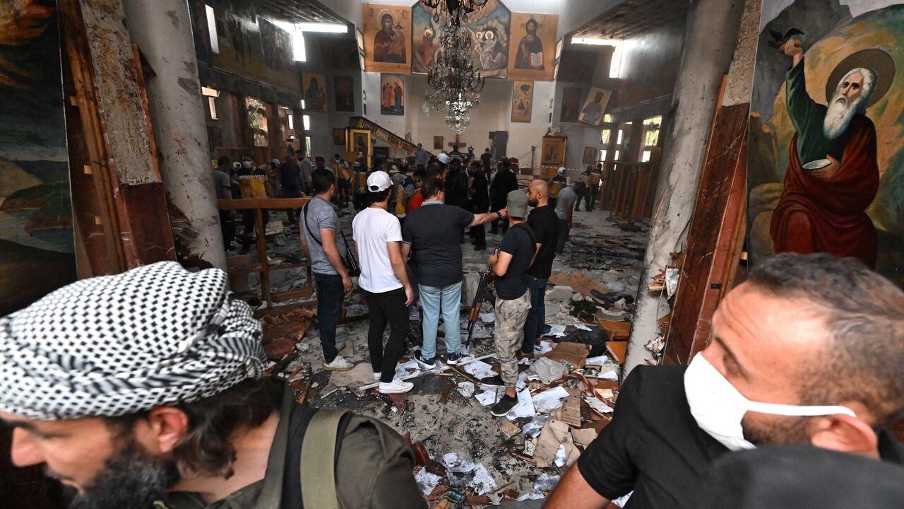 People and rescuers inspect the damage at the site of a reported suicide attack at the Saint Elias church in Damascus on June 22, 2025. 