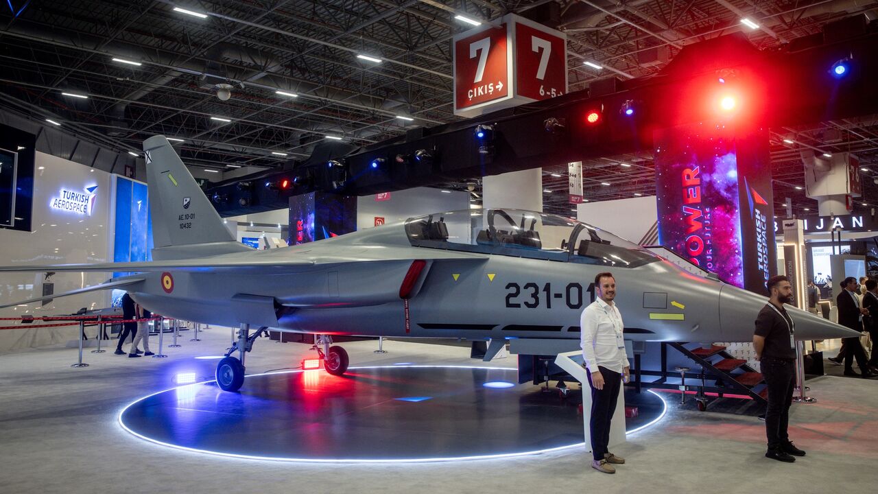 People pose for photographs in front of a Turkish Hurjet at the 17th International Defense Industry Fair (IDEF), Istanbul, July 24, 2025.