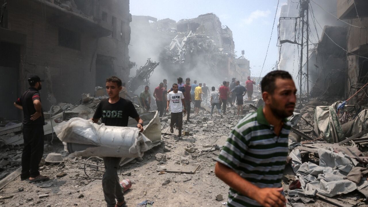 Palestinians following a strike on Gaza City, which Israel would 'take control' of under a new plan