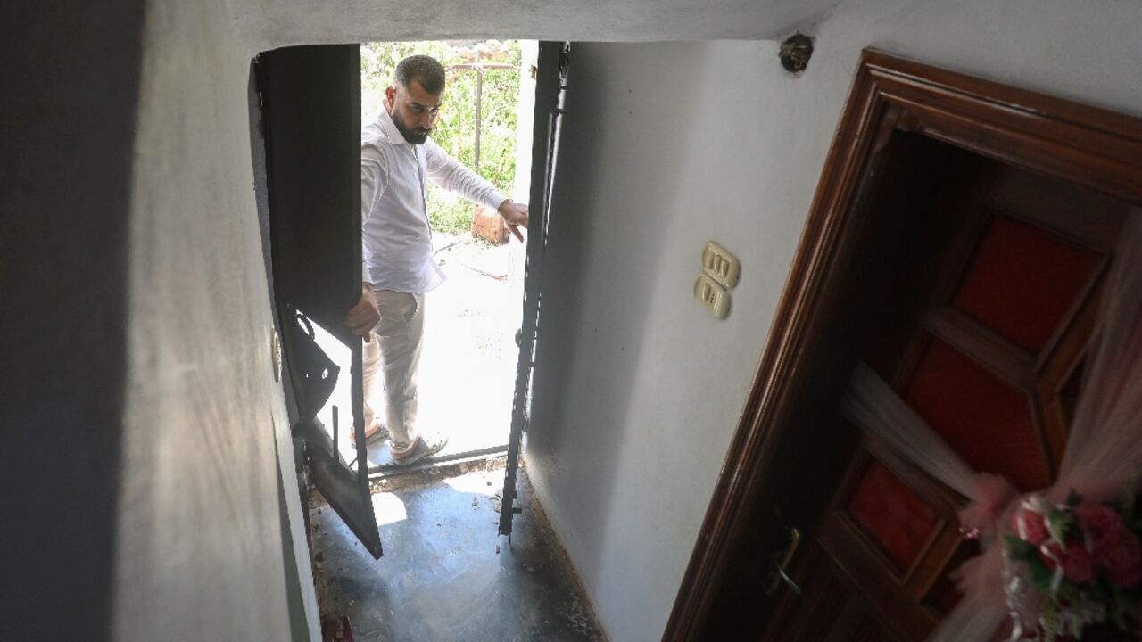 A man opens the door to a house, the site of a reported operation by the US-led anti-jihadist coalition, in the town of Atme in northwestern Syria